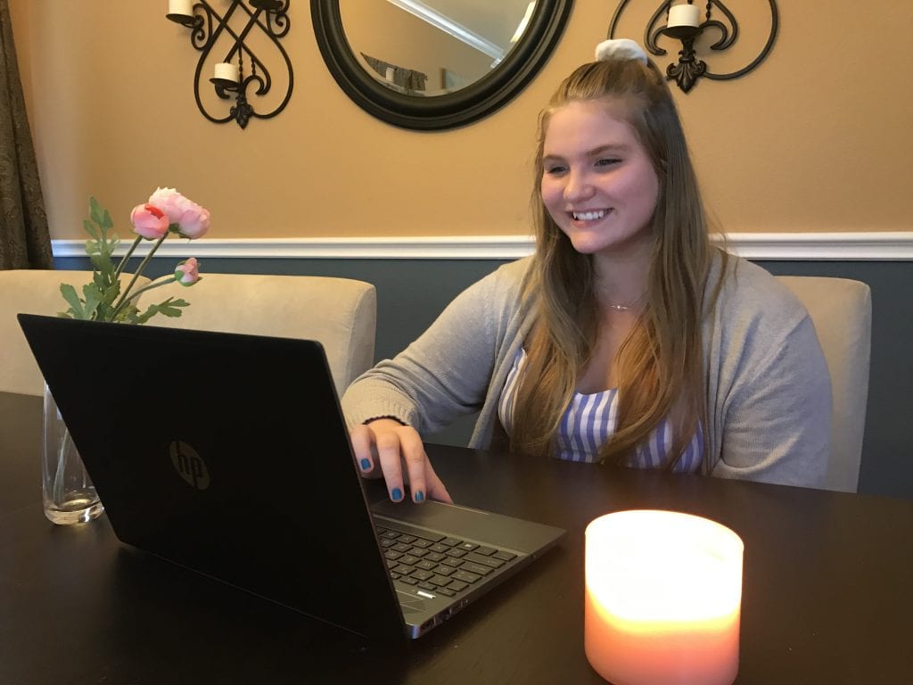 A person enjoying an activity on her laptop.